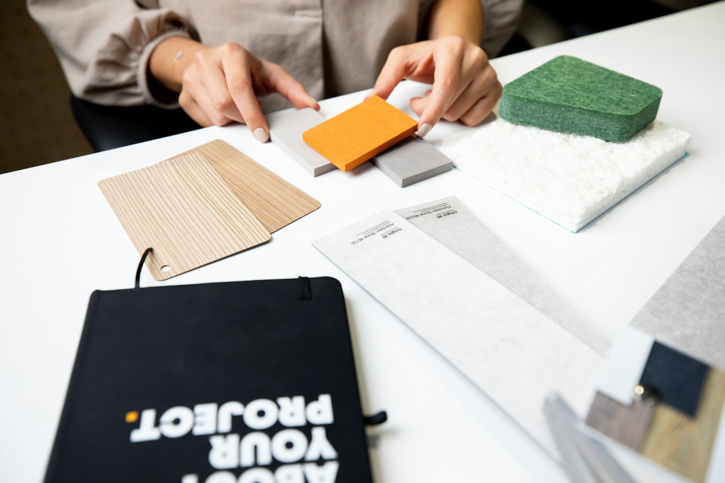 Handen sorteren materiaalstalen zoals hout en stof.